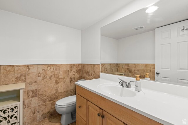 1933 N 120 W, Tooele, UT 84074 - bathroom featuring tile walls, toilet, vanity, and a wainscoted wall