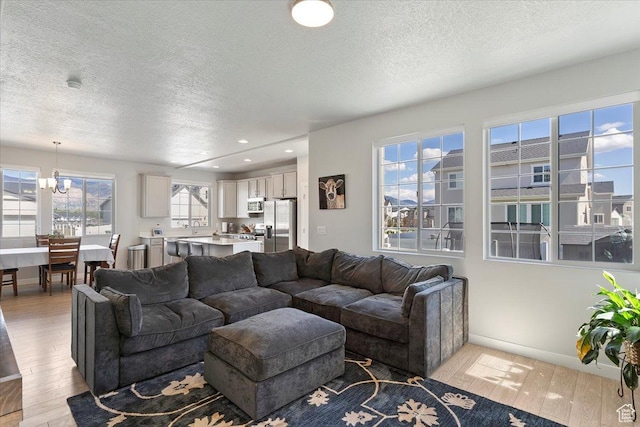 2221 W Prevedel Dr S, West Haven, UT 84401 - living area featuring a textured ceiling, light wood-type flooring, recessed lighting, a chandelier, and baseboards