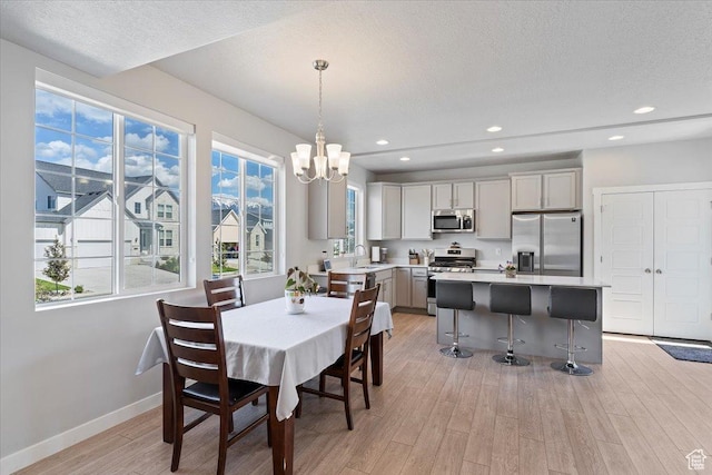 2221 W Prevedel Dr S, West Haven, UT 84401 - dining room featuring light wood-type flooring, a chandelier, baseboards, a textured ceiling, and recessed lighting