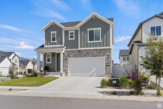 2221 W Prevedel Dr S, West Haven, UT 84401 - view of front of home featuring board and batten siding, an attached garage, stone siding, and driveway
