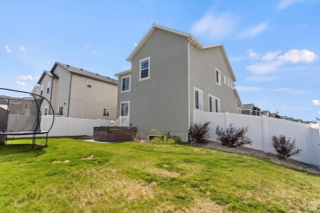 2221 W Prevedel Dr S, West Haven, UT 84401 - rear view of property featuring a hot tub, a trampoline, and stucco siding