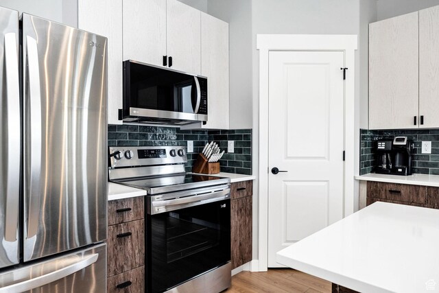 660 N Lochwood Dr # 69, Garden City, UT 84028 - kitchen featuring stainless steel appliances, light countertops, tasteful backsplash, and light wood finished floors