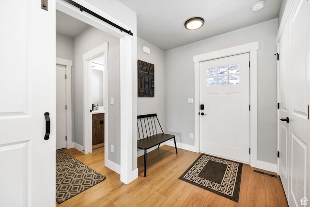 660 N Lochwood Dr # 69, Garden City, UT 84028 - entrance foyer with a barn door, light wood-type flooring, and baseboards