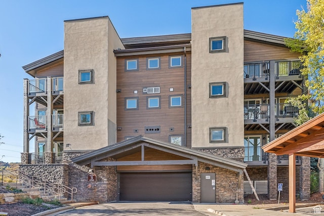6749 N 2200 W Unit B102, Park City, UT 84098 - view of apartment building / complex featuring an attached garage and driveway