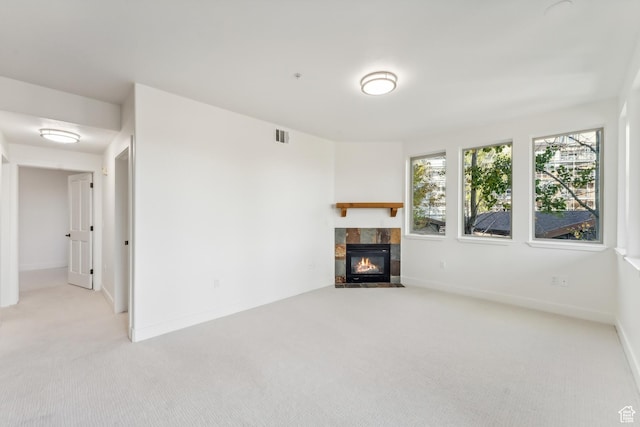 6749 N 2200 W Unit B102, Park City, UT 84098 - unfurnished living room with carpet floors, a tiled fireplace, and baseboards