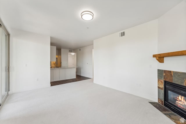 6749 N 2200 W Unit B102, Park City, UT 84098 - unfurnished living room with carpet, a tile fireplace, and baseboards