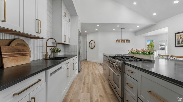 5557 W 13680 S, Herriman, UT 84096 - kitchen with stainless steel appliances, a sink, dark countertops, recessed lighting, and light wood-style floors