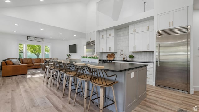 5557 W 13680 S, Herriman, UT 84096 - kitchen with built in refrigerator, dark countertops, a sink, light wood-style floors, and recessed lighting