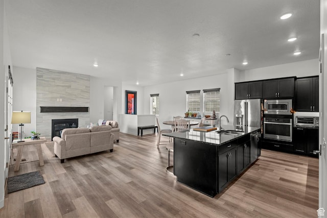 11242 S Willow Dr, South Jordan, UT 84009 - kitchen featuring stainless steel appliances, dark cabinetry, a sink, light wood-style flooring, and recessed lighting