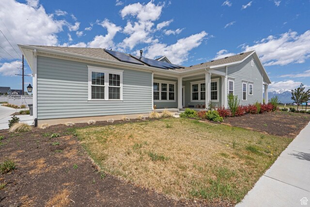 11242 S Willow Dr, South Jordan, UT 84009 - rear view of property with roof mounted solar panels, covered porch, and a lawn