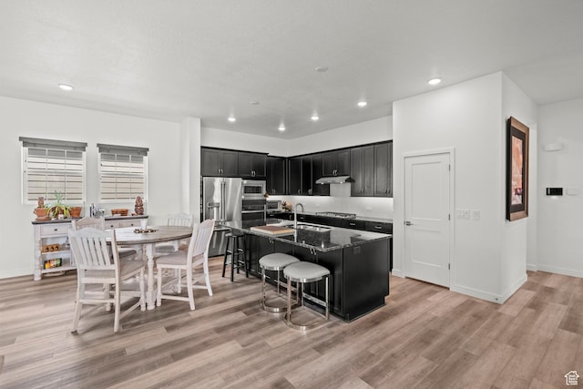 11242 S Willow Dr, South Jordan, UT 84009 - kitchen with appliances with stainless steel finishes, dark cabinetry, recessed lighting, light wood-type flooring, and a kitchen bar