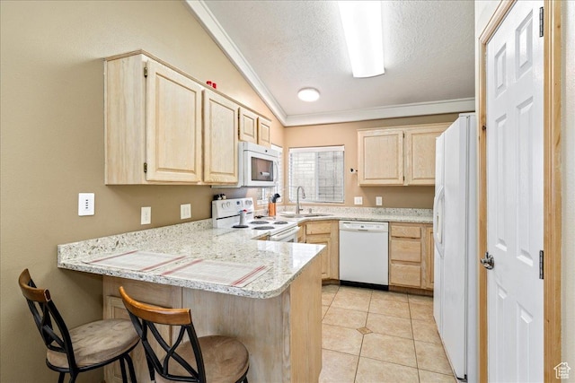 1040 N 1300th St Unit 52, St George, UT 84770 - kitchen featuring white appliances, light brown cabinetry, a peninsula, crown molding, and a sink