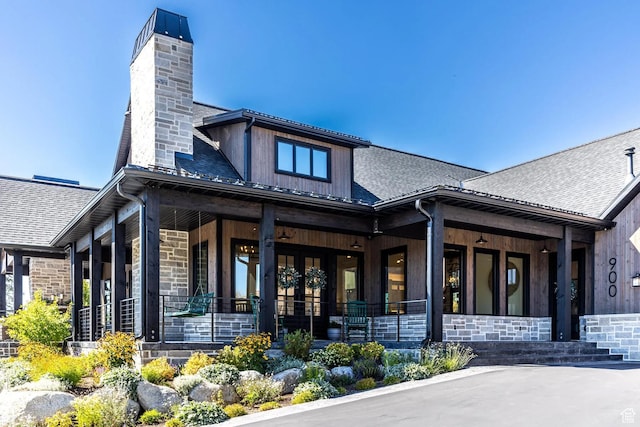 900 W Weber Canyon Rd, Oakley, UT 84055 - back of house with a porch, a chimney, stone siding, and roof with shingles
