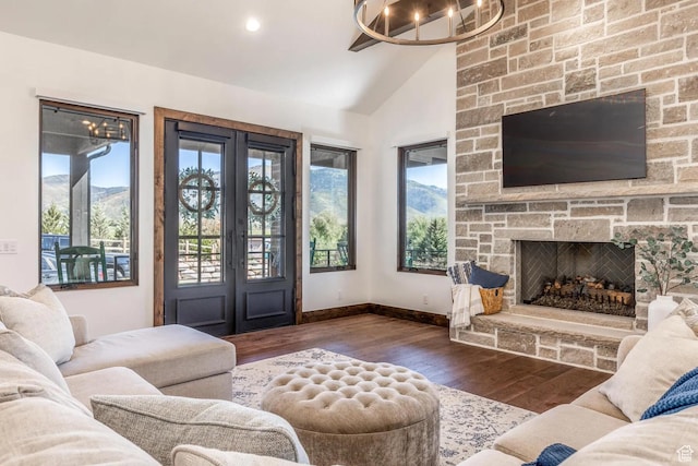 900 W Weber Canyon Rd, Oakley, UT 84055 - living room with wood finished floors, vaulted ceiling, a fireplace, baseboards, and a chandelier