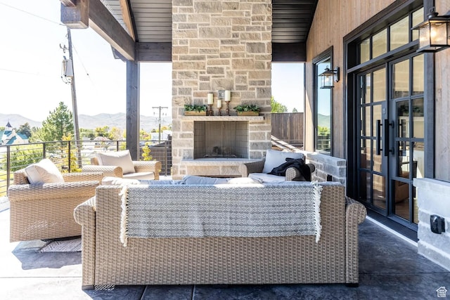 900 W Weber Canyon Rd, Oakley, UT 84055 - view of patio / terrace featuring french doors, a mountain view, and an outdoor living space with a fireplace