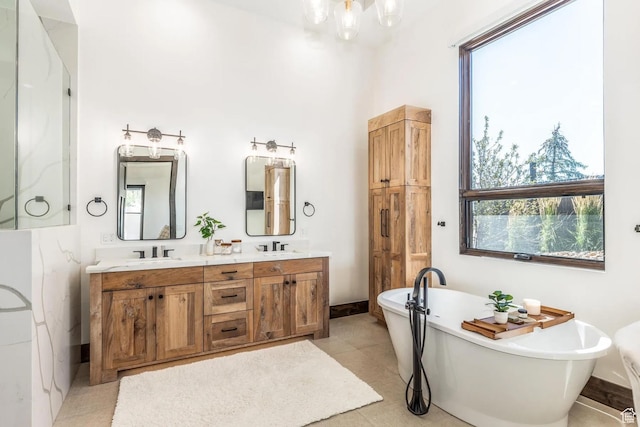 900 W Weber Canyon Rd, Oakley, UT 84055 - bathroom featuring a soaking tub, double vanity, a chandelier, and baseboards