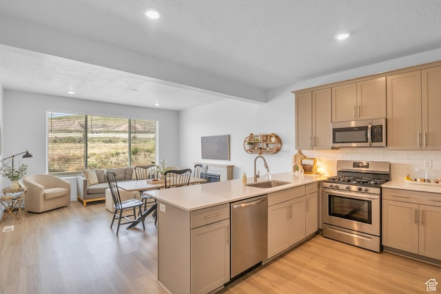 3791 W Soft Whisper Way, Herriman, UT 84096 - kitchen with appliances with stainless steel finishes, a sink, a peninsula, light countertops, and backsplash