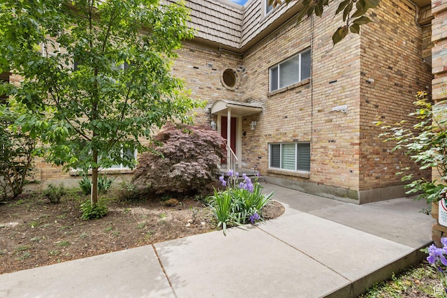 2220 E Murray Holladay Rd Unit 156, Holladay, UT 84117 - doorway to property featuring brick siding and mansard roof