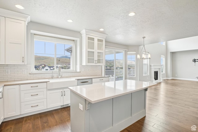 15056 S Sage Terrace Ln Unit 1014, Herriman, UT 84096 - kitchen with a sink, backsplash, a textured ceiling, light countertops, and white cabinetry