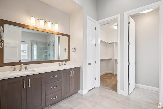 15056 S Sage Terrace Ln Unit 1014, Herriman, UT 84096 - full bathroom featuring a stall shower, a spacious closet, double vanity, baseboards, and tile patterned floors