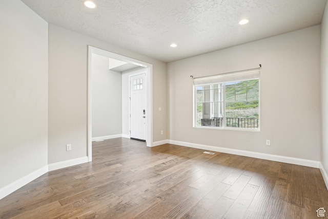 15056 S Sage Terrace Ln Unit 1014, Herriman, UT 84096 - empty room with wood finished floors, recessed lighting, baseboards, and a textured ceiling