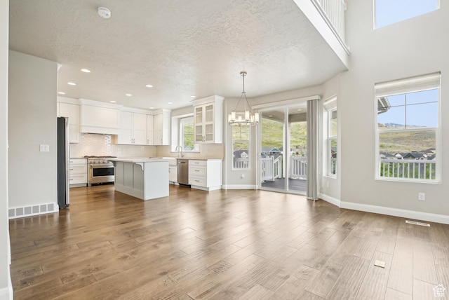 15056 S Sage Terrace Ln Unit 1014, Herriman, UT 84096 - unfurnished living room with a chandelier, a textured ceiling, dark wood-style floors, recessed lighting, and baseboards