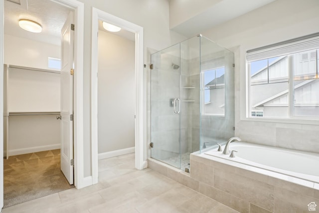 15056 S Sage Terrace Ln Unit 1014, Herriman, UT 84096 - bathroom with a shower stall, a spacious closet, a garden tub, tile patterned floors, and baseboards
