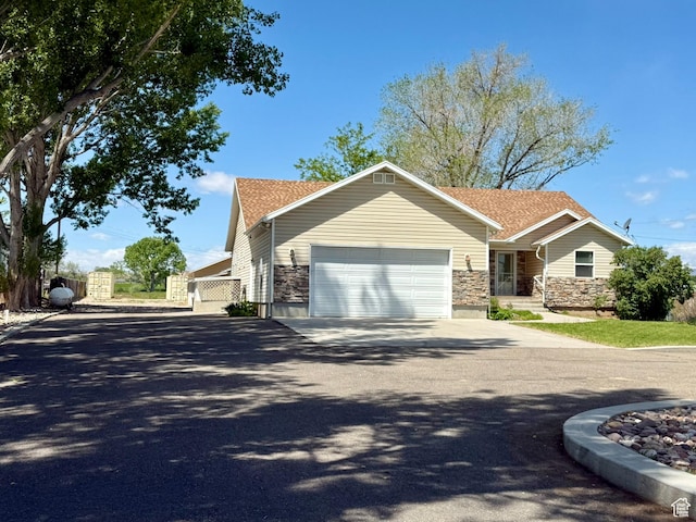 3870 S 2500 E, Vernal, UT 84078 - view of front of property featuring asphalt driveway, a garage, and stone siding