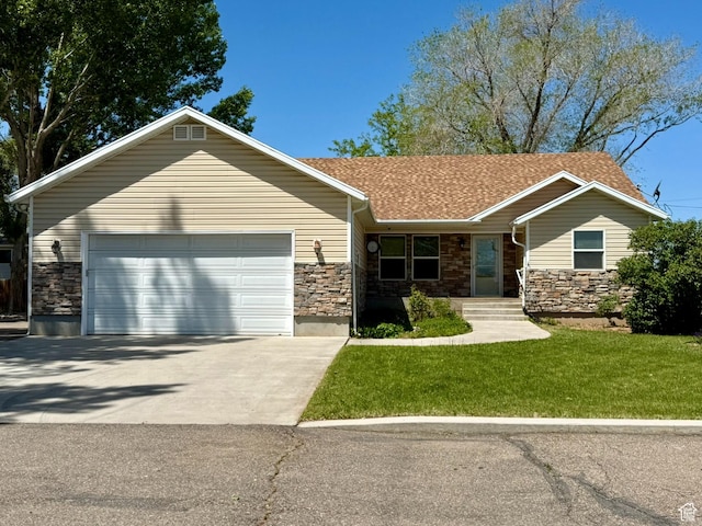 3870 S 2500 E, Vernal, UT 84078 - ranch-style house with stone siding, concrete driveway, an attached garage, and a front lawn