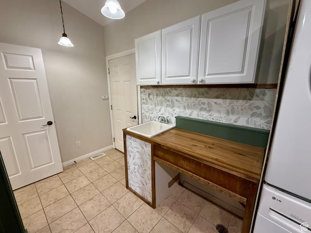 3870 S 2500 E, Vernal, UT 84078 - laundry area with stacked washer / drying machine, cabinet space, light tile patterned floors, and baseboards
