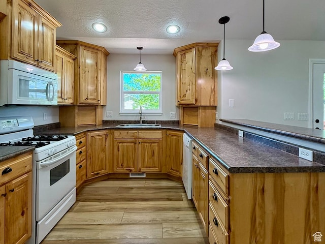 3870 S 2500 E, Vernal, UT 84078 - kitchen featuring white appliances, a sink, a peninsula, light wood finished floors, and pendant lighting