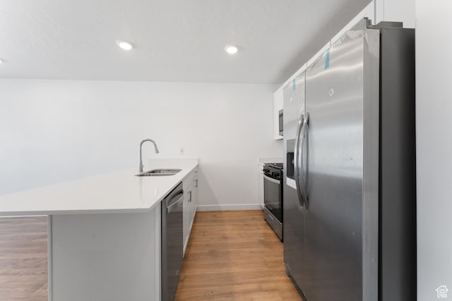 3457 E 1320 S, Spanish Fork, UT 84660 - kitchen featuring stainless steel appliances, a peninsula, a sink, light wood finished floors, and white cabinets