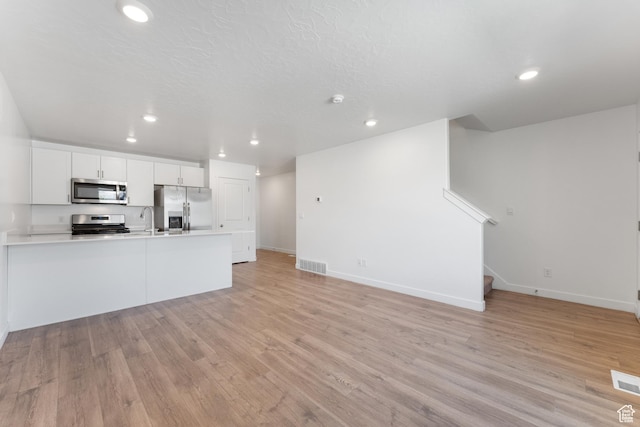 3457 E 1320 S, Spanish Fork, UT 84660 - unfurnished living room featuring light wood finished floors, stairway, a sink, recessed lighting, and baseboards
