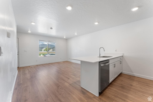3457 E 1320 S, Spanish Fork, UT 84660 - kitchen with stainless steel dishwasher, a sink, a peninsula, light wood-type flooring, and light countertops
