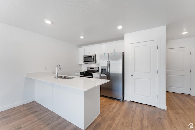 3457 E 1320 S, Spanish Fork, UT 84660 - kitchen with appliances with stainless steel finishes, a sink, light wood-style flooring, a peninsula, and white cabinetry