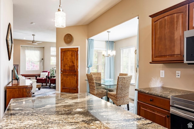 2271 W New Harvest Ln, Lehi, UT 84043 - kitchen with electric range, plenty of natural light, a chandelier, and brown cabinets