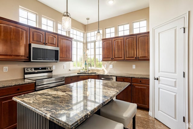2271 W New Harvest Ln, Lehi, UT 84043 - kitchen with stainless steel appliances, a sink, stone countertops, a kitchen breakfast bar, and decorative light fixtures