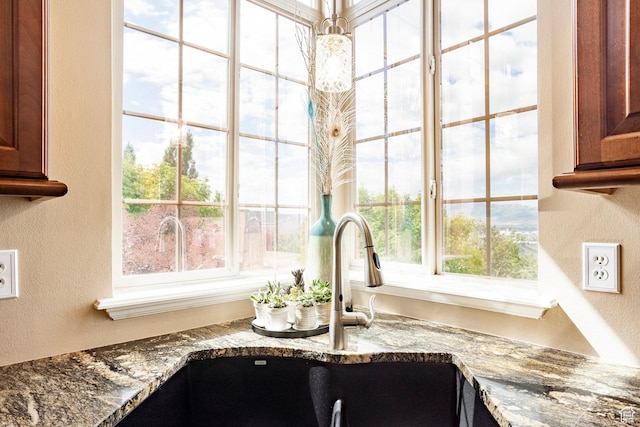 2271 W New Harvest Ln, Lehi, UT 84043 - kitchen view of a textured wall, a sink, stone counters, and brown cabinetry