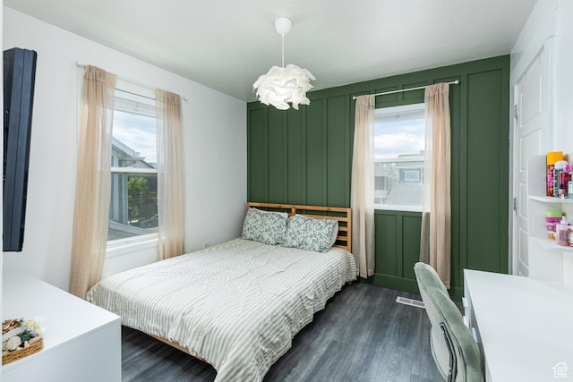 15187 S Sabre Pl, Bluffdale, UT 84065 - bedroom featuring dark wood-type flooring, multiple windows, and a decorative wall