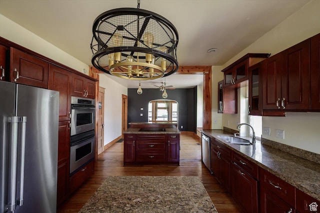 625 S 400 E, Salt Lake City, UT 84111 - kitchen featuring stainless steel appliances, a sink, reddish brown cabinets, dark wood-type flooring, and a center island
