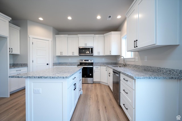 1244 N 350 W Unit 35, Brigham City, UT 84302 - kitchen with appliances with stainless steel finishes, light wood-type flooring, a kitchen island, white cabinets, and recessed lighting