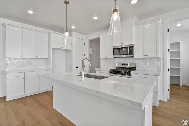 1323 E 370 S, Payson, UT 84651 - kitchen featuring appliances with stainless steel finishes, a sink, white cabinetry, a center island with sink, and backsplash