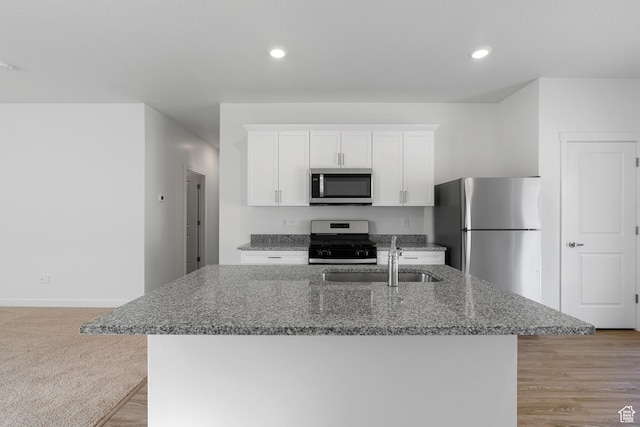 7164 Oquirrh Ranch Pkwy N, Eagle Mountain, UT 84005 - kitchen featuring stainless steel appliances, a sink, an island with sink, white cabinets, and dark stone countertops