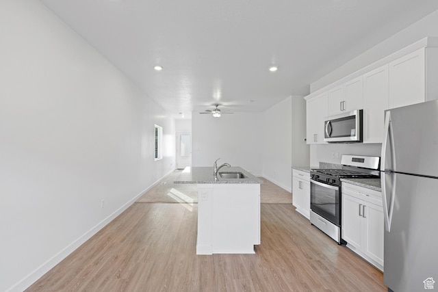 7164 Oquirrh Ranch Pkwy N, Eagle Mountain, UT 84005 - kitchen with appliances with stainless steel finishes, white cabinets, an island with sink, light wood-type flooring, and recessed lighting