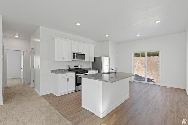 7164 Oquirrh Ranch Pkwy N, Eagle Mountain, UT 84005 - kitchen with stainless steel appliances, a sink, a center island with sink, recessed lighting, and white cabinets