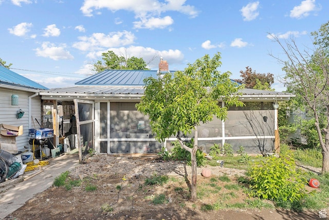 142 N Pinehurst Ave, Tooele, UT 84074 - rear view of house featuring a sunroom, a chimney, and metal roof