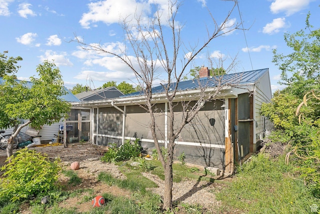 142 N Pinehurst Ave, Tooele, UT 84074 - back of property featuring metal roof, a sunroom, and a chimney