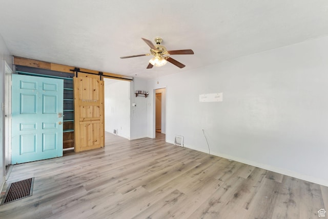 142 N Pinehurst Ave, Tooele, UT 84074 - spare room featuring ceiling fan, a barn door, and light wood-style flooring