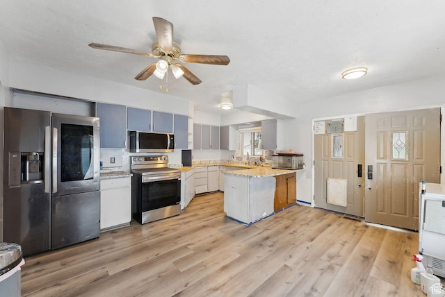 142 N Pinehurst Ave, Tooele, UT 84074 - kitchen with appliances with stainless steel finishes, a peninsula, ceiling fan, light wood-type flooring, and a sink