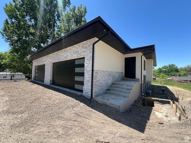 7230 S 525 E, Midvale, UT 84047 - view of home's exterior featuring stucco siding, dirt driveway, and stone siding
